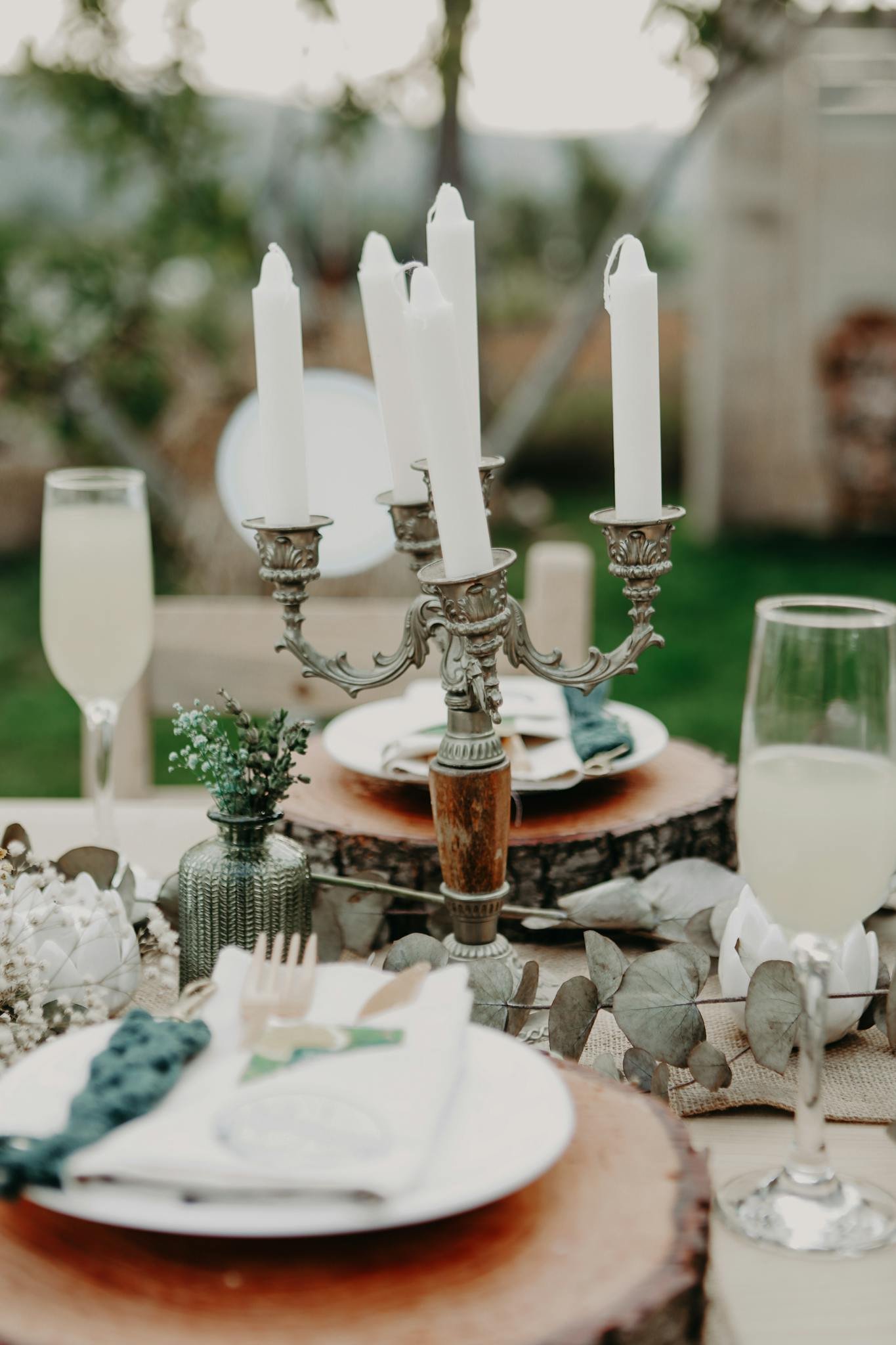 Charming rustic table setting outdoors with candles and decoration.