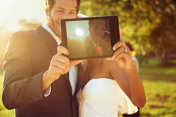 Wedding trends, bride and groom hold up an ipad