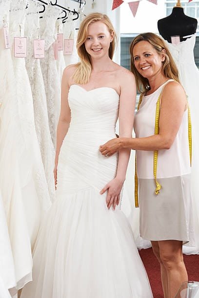 Bride getting fitted for a wedding dress