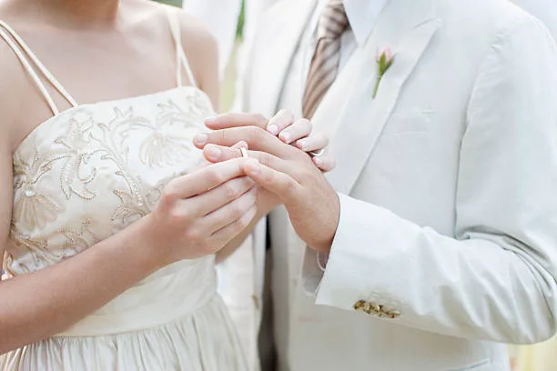 bride and groom exchange rings during wedding ceremony